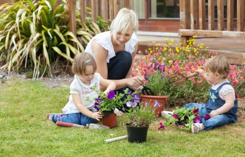 Family-friendly landscape gardening in Norbury with lawn and seating